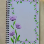 A notebook featuring a design of purple flowers and green leaves on the front cover, showcasing creative design ideas.