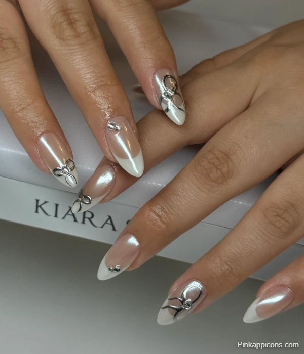 Elegant White French Tip Nails with Silver Bow Charms and Rhinestones