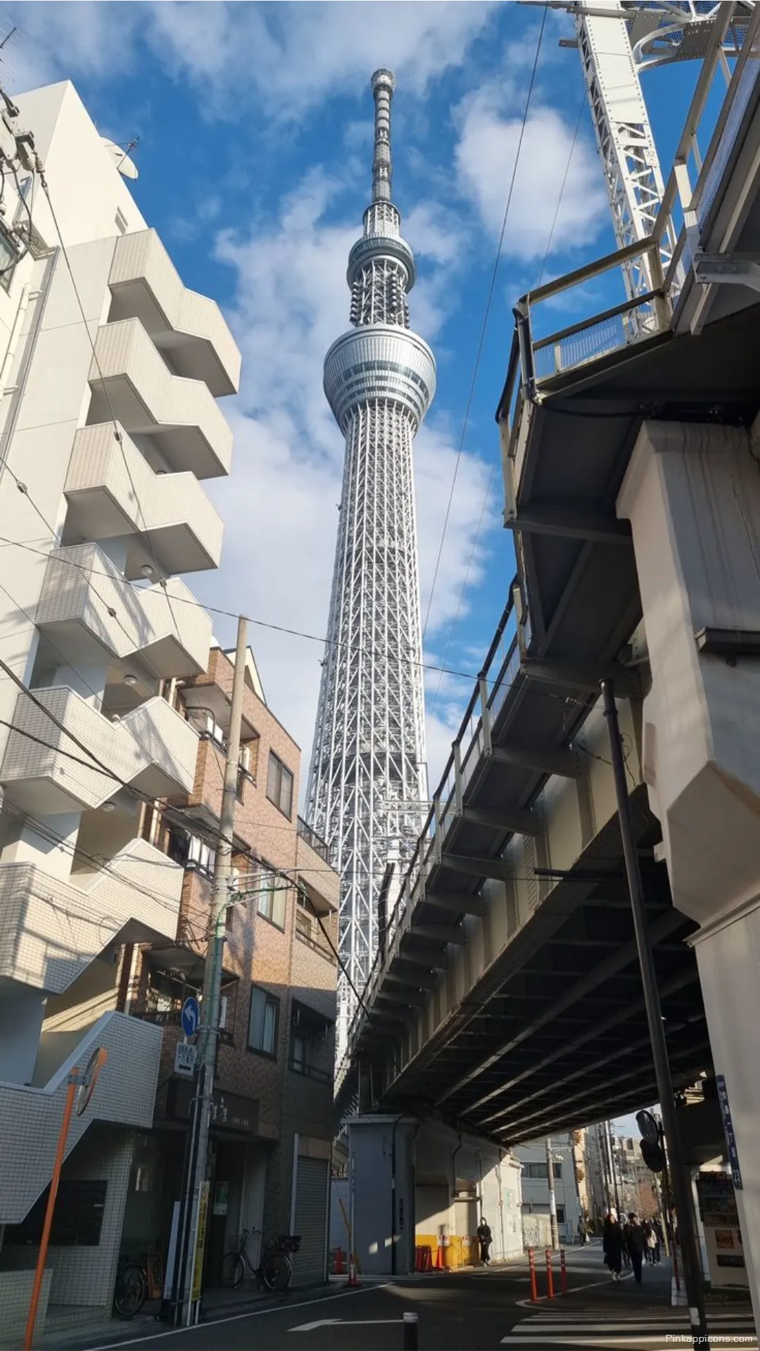 Discover the iconic Tokyo Skytree framed by city buildings and an elevated track a unique Tokyo wallpaper for your mobile Discover the iconic Tokyo Skytree framed by city buildings and an elevated track, a unique Tokyo wallpaper for your mobile